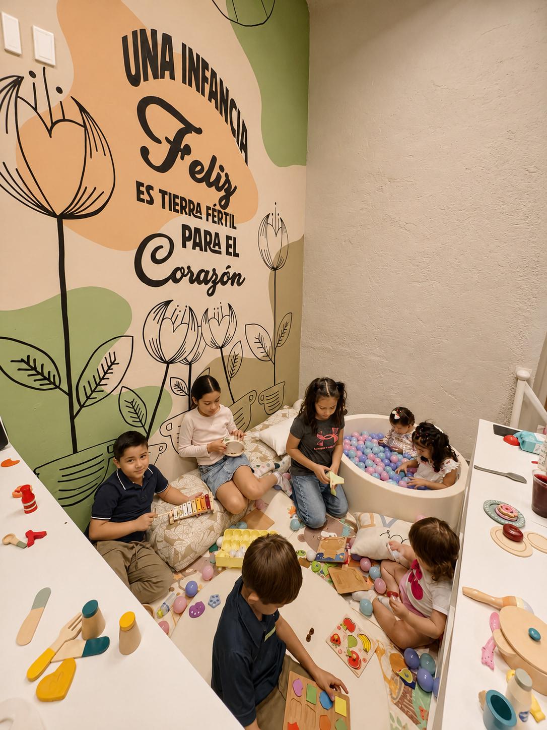 Alere kids' nook · children playing by the mural and ball pit